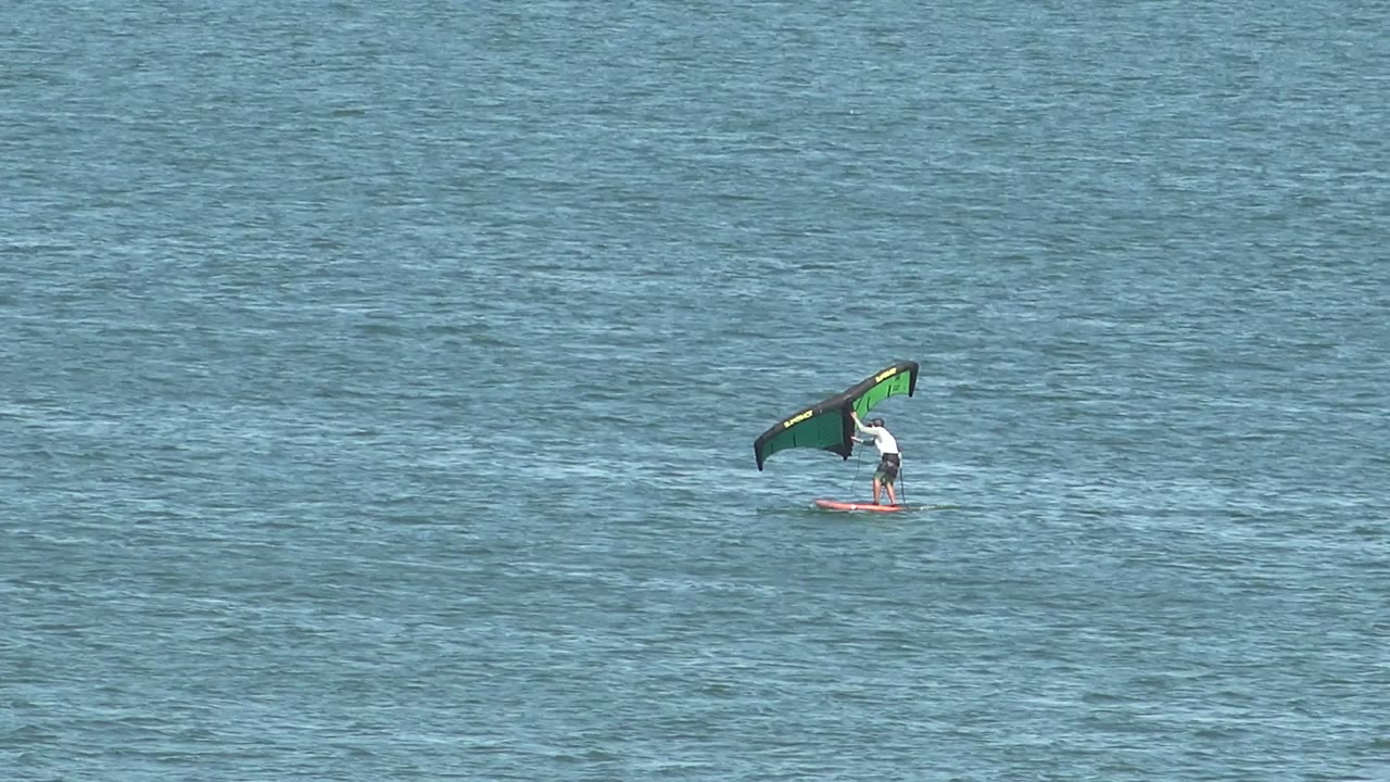 Kite surfer centered on open blue water.