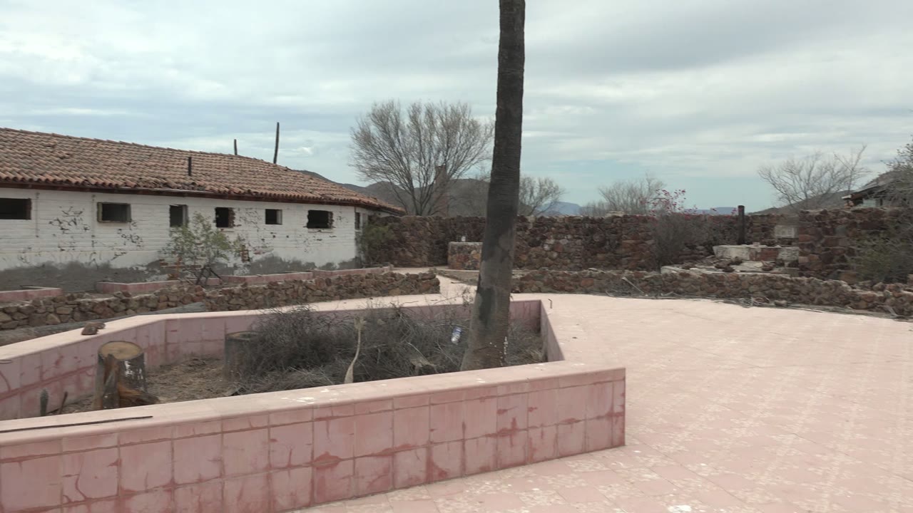 Red-roof white building and stone courtyard seen during pan