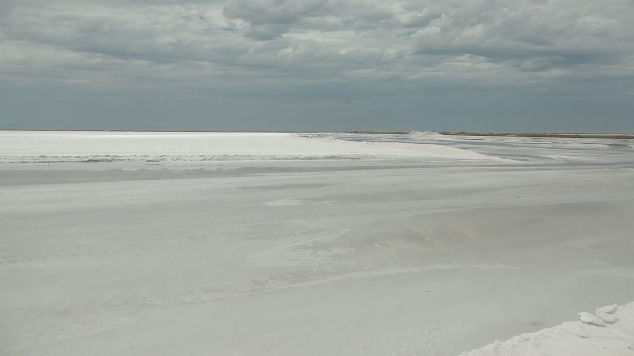 Snow-lined frozen surface with distant horizon and clouds
