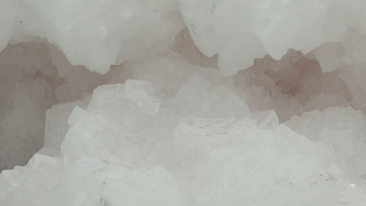Close frame of the ice crystals one second in, with a dense white surface, softened translucent edges, and no visible people in the Guerrero Negro clip.