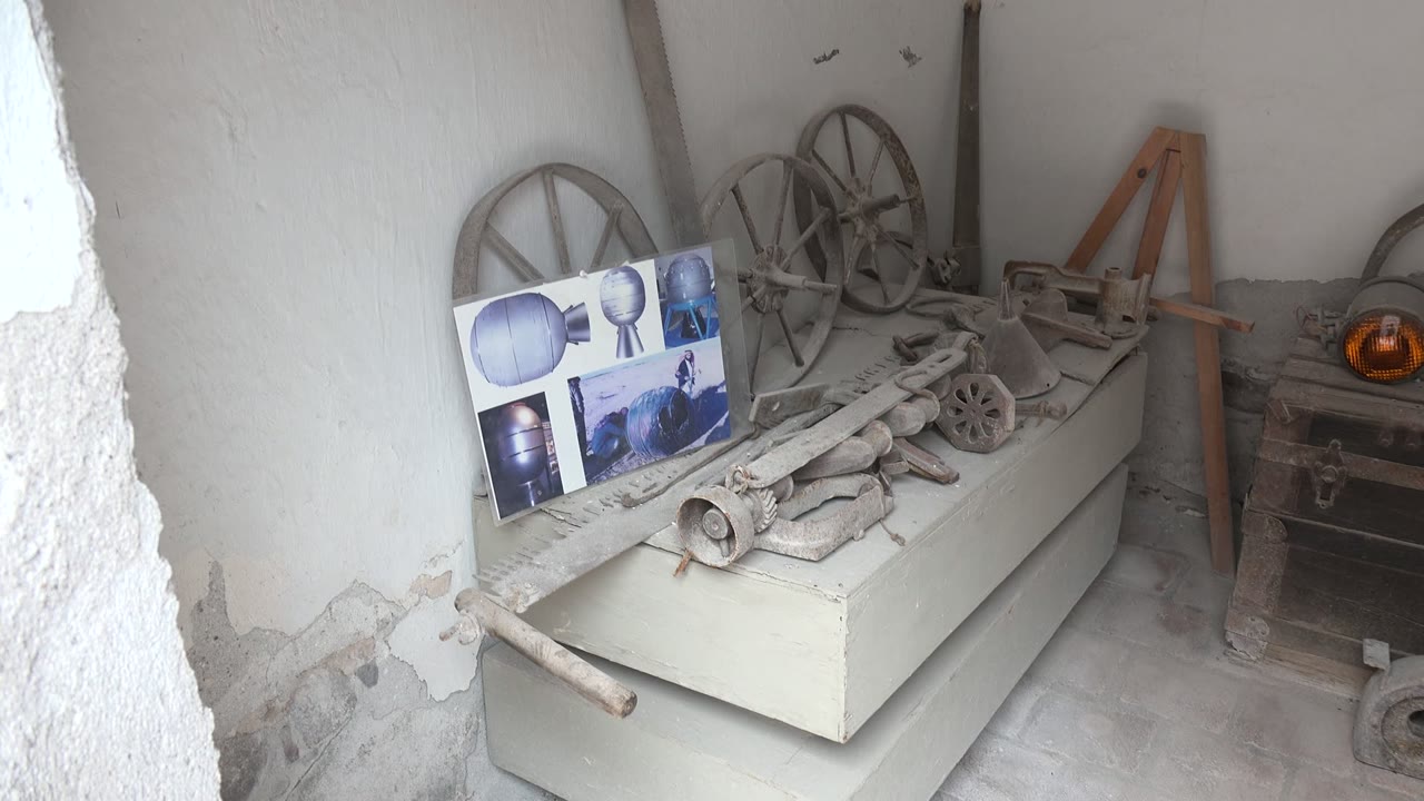 At the start of the Mulege, Baja California Sur clip, a white cabinet holds dusty wooden and metal tools beside posters, wagon wheels, a wooden chest, and no visible people.