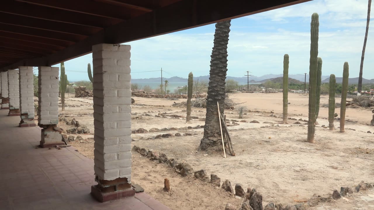 White column under roof beside cactus garden and distant hills