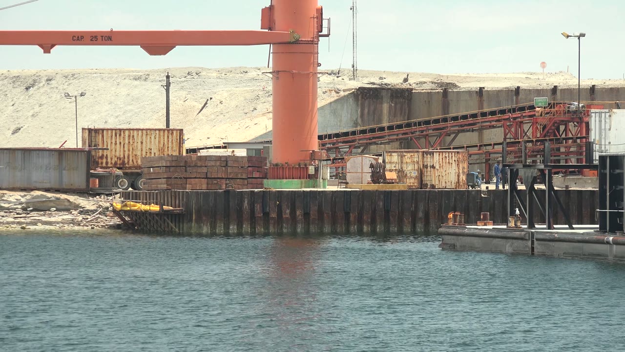 Industrial crane and dock with water in the foreground