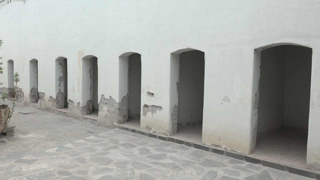 White courtyard arches with the edge of an old boat planter entering from the right.
