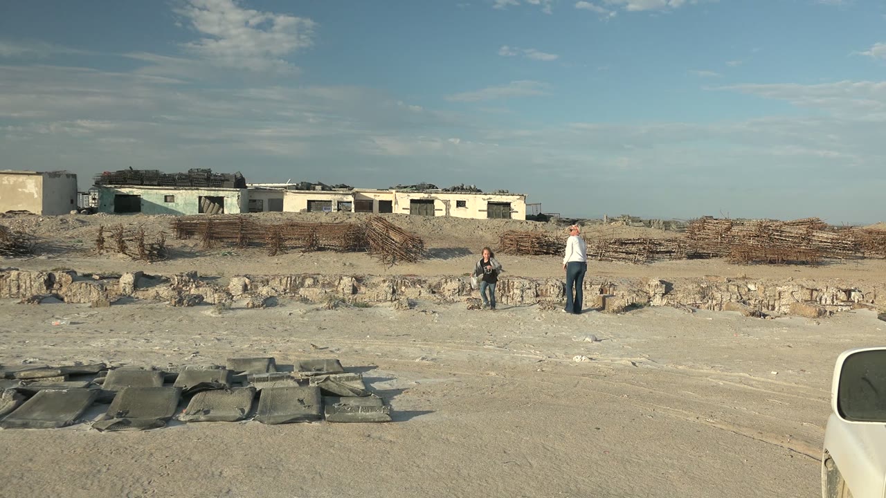 Child and adult beginning to walk across sandy ground