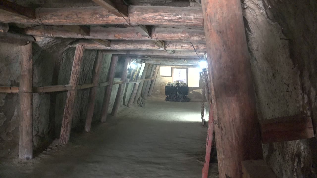 Santa Rosalia tunnel interior with a large right-side foreground post, slanted wooden supports along the wall, and no visible people in the frame.