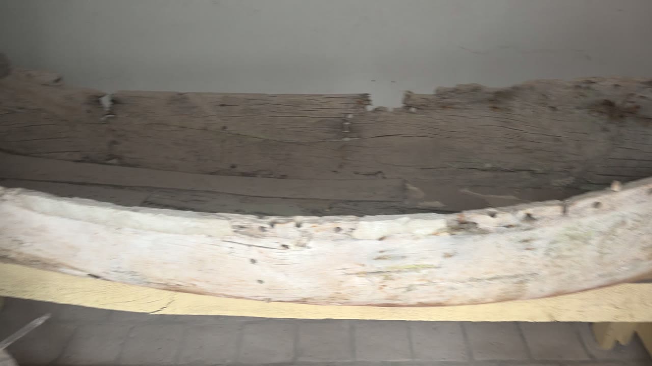Long section of worn wooden boat with visible nails