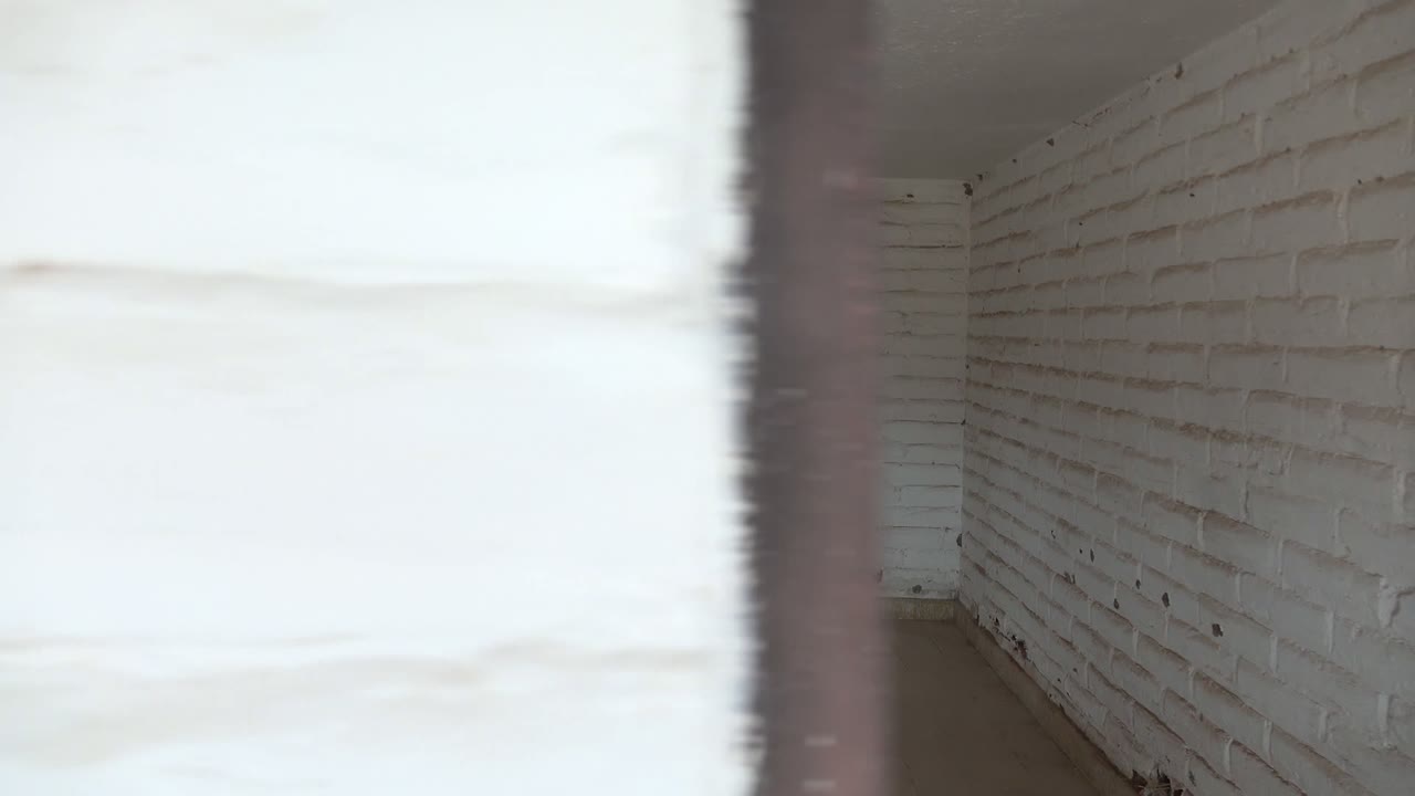 Blurred doorway passage into white brick interior