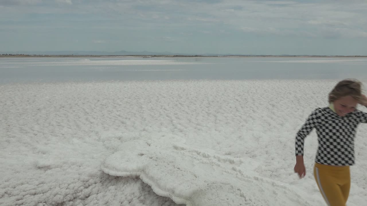 Child passing close to camera on the left edge of the salt flat.