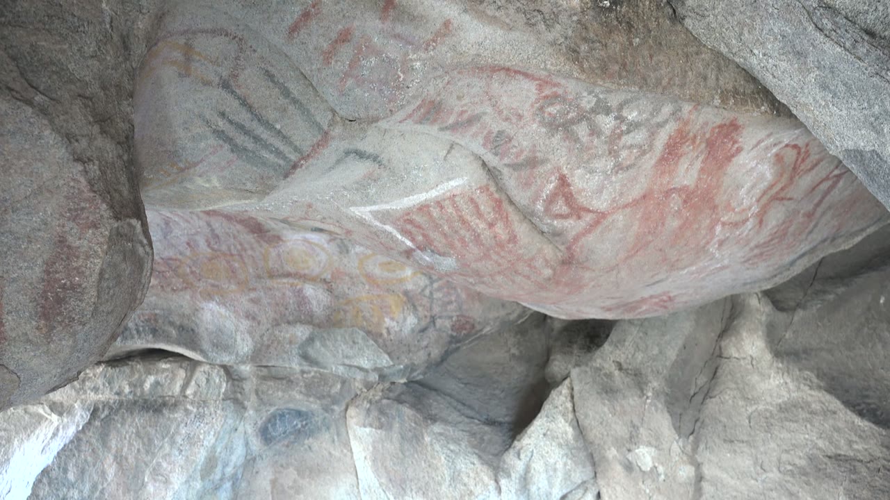 Faded red pigment across uneven ceiling rock