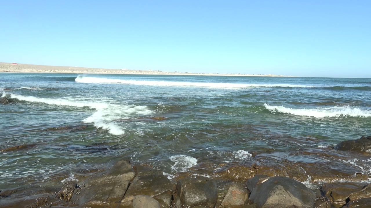 Foamy surf moving across rocky coastal water