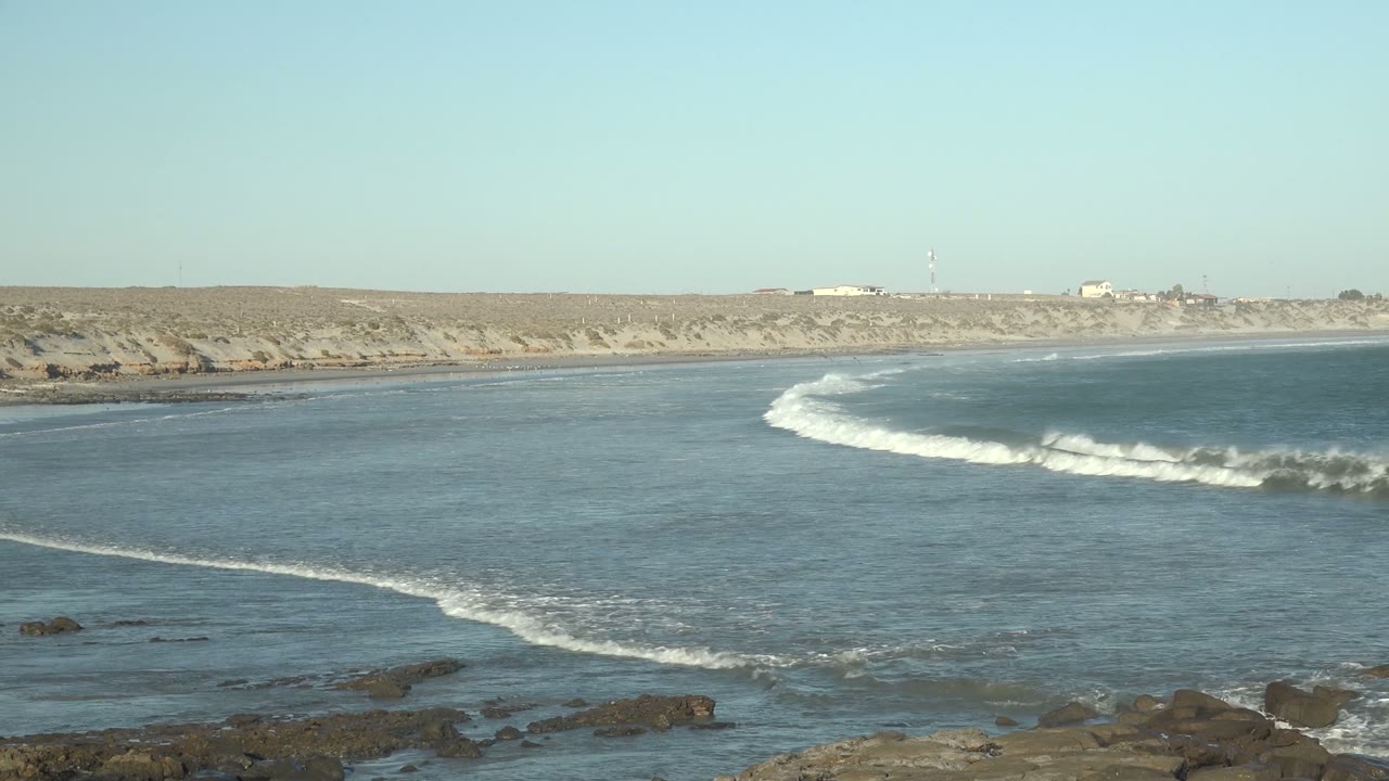 Curving wave line crossing blue coastal water