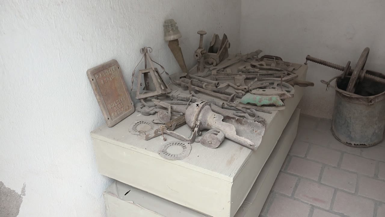 Old hand tools and circular metal pieces on a cabinet