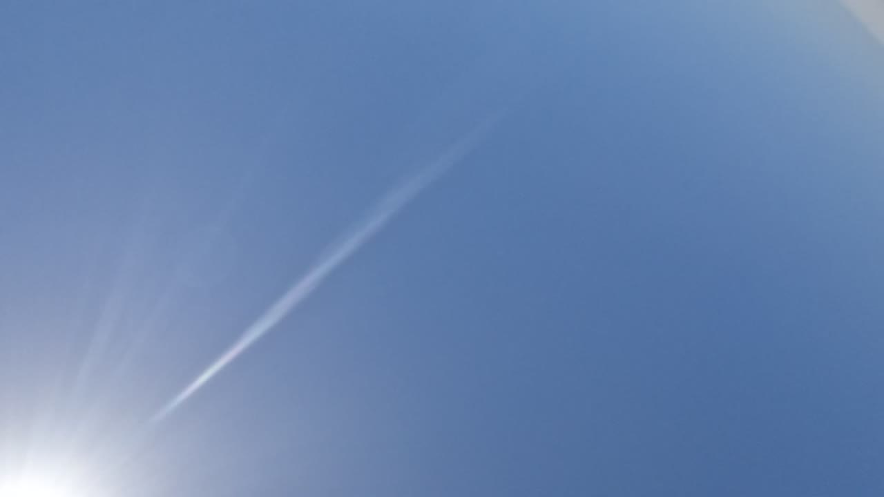 Clear blue Baja California sky with the bright sun flaring near the lower left and a pale streak across the frame, with no visible people.