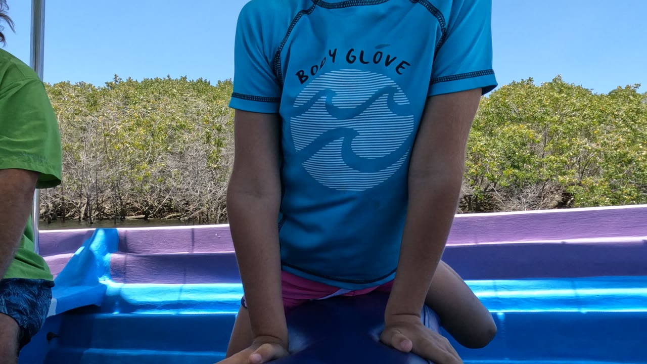 Child leaning forward on boat with hands down