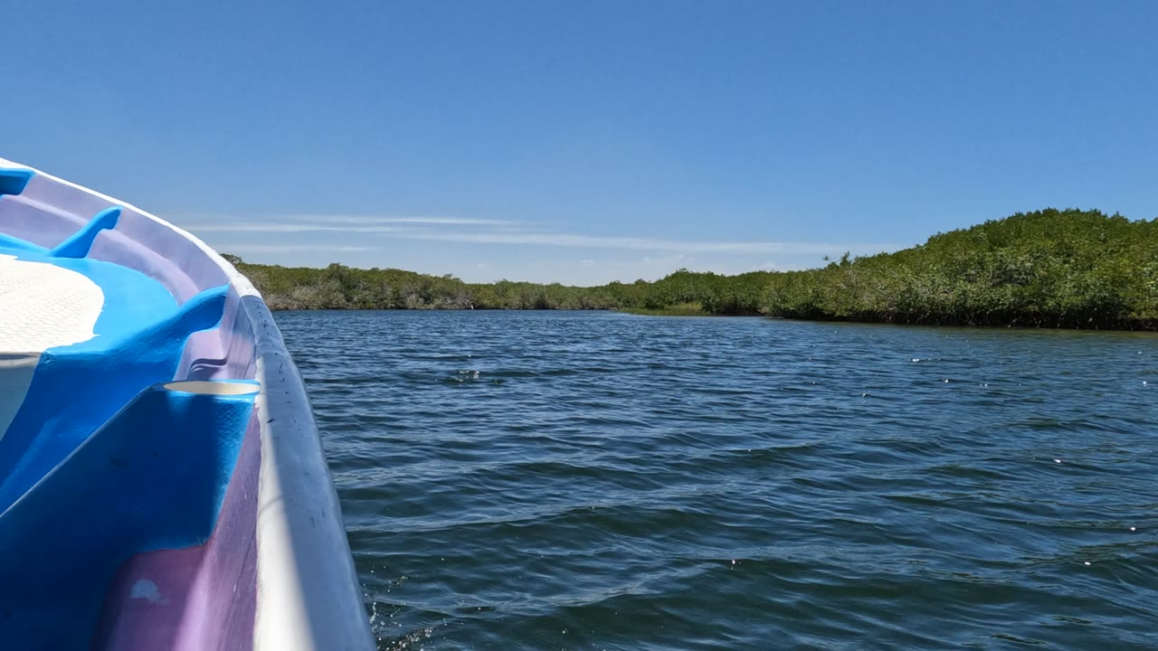 At two seconds, the boat prow sits left of center, open rippled water fills the midground, the Baja California shore appears low and green, and no visible people are present.