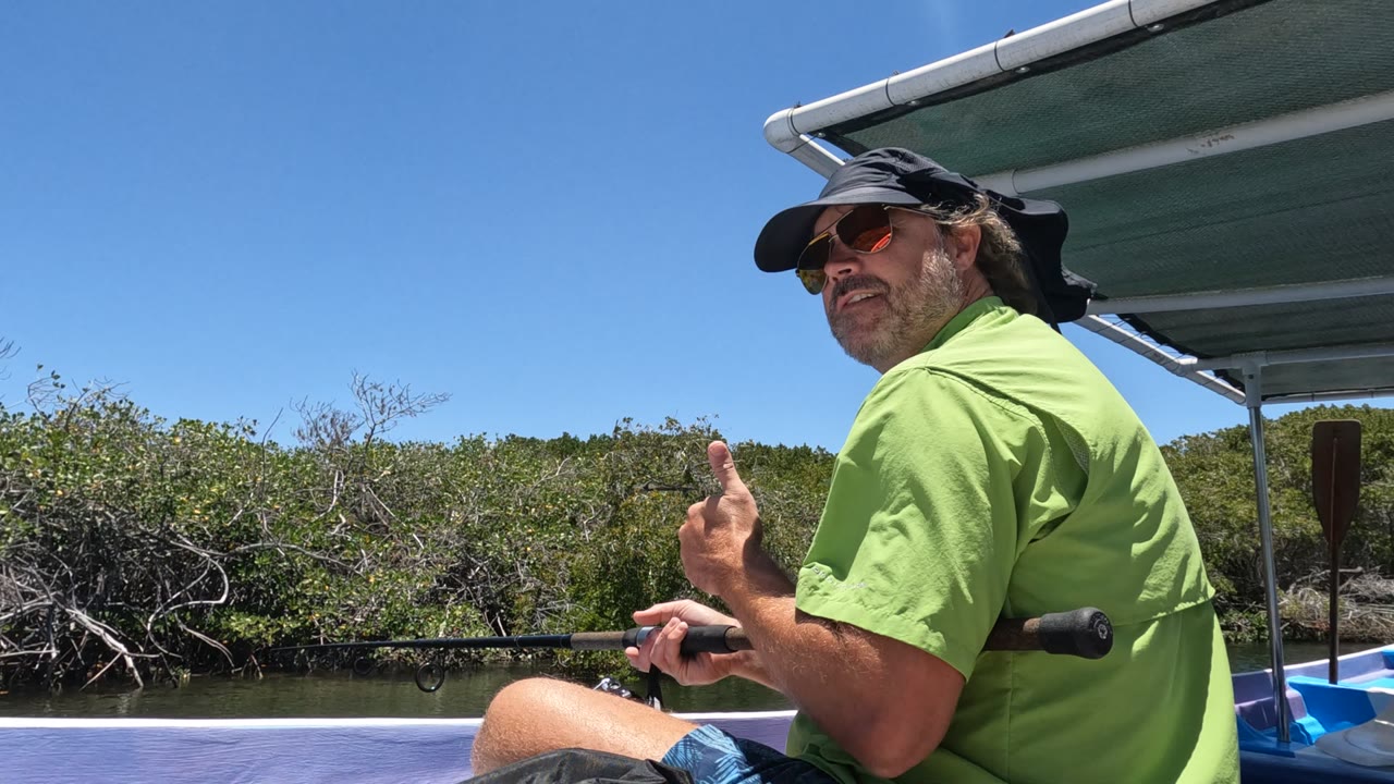 Seated fisherman on a boat turns slightly while holding a rod.