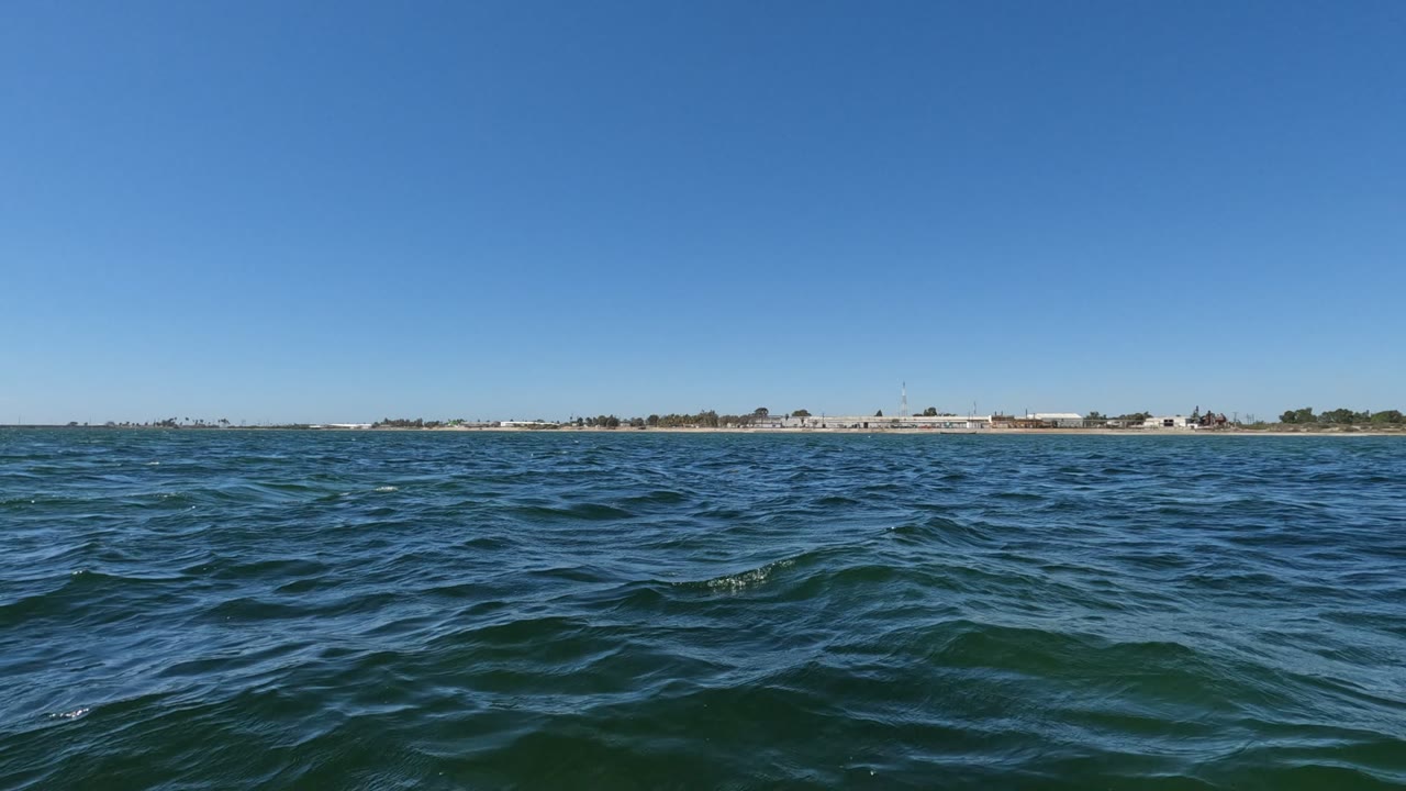 Low ocean view with rippled water and far shore.