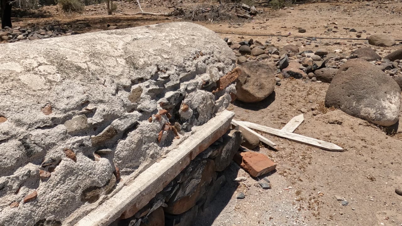 Broken concrete and exposed brick fill the foreground at a dry stone construction site in Baja California, Mexico, with no visible people in this frame.