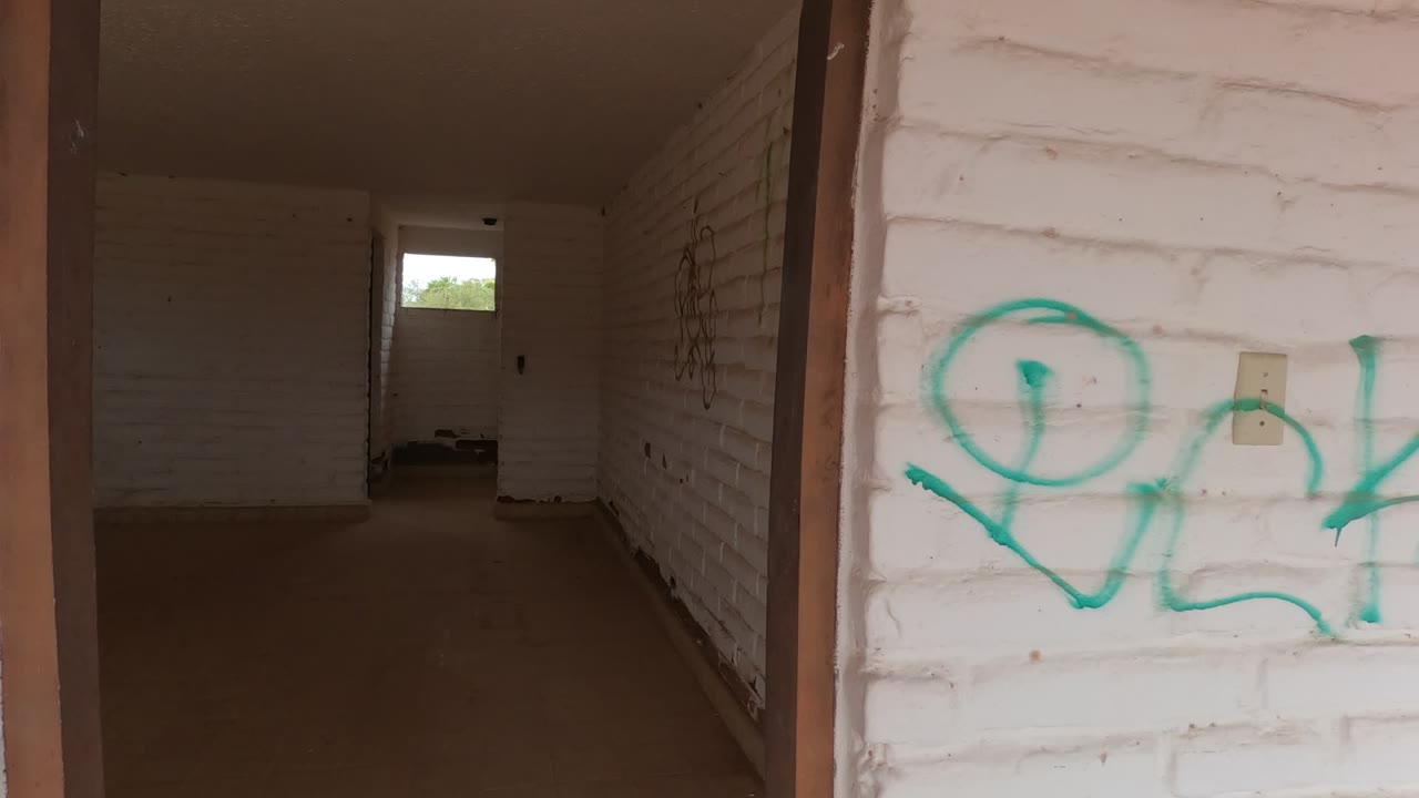 Empty corridor with white brick side wall and bright small window at the far end