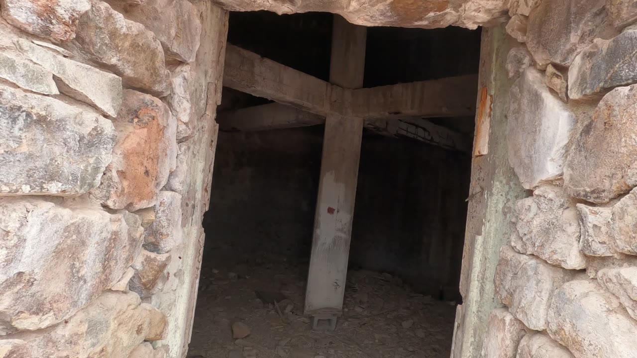 Stone doorway framing a dim room with a central support.