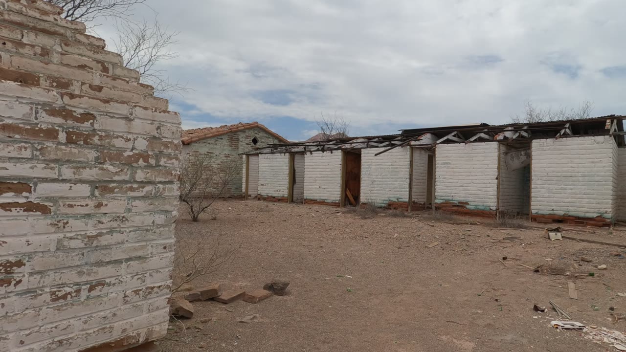 At 0:02, a tall weathered brick wall dominates the foreground in Baja California, Mexico, with damaged roof framing and no visible people behind it.