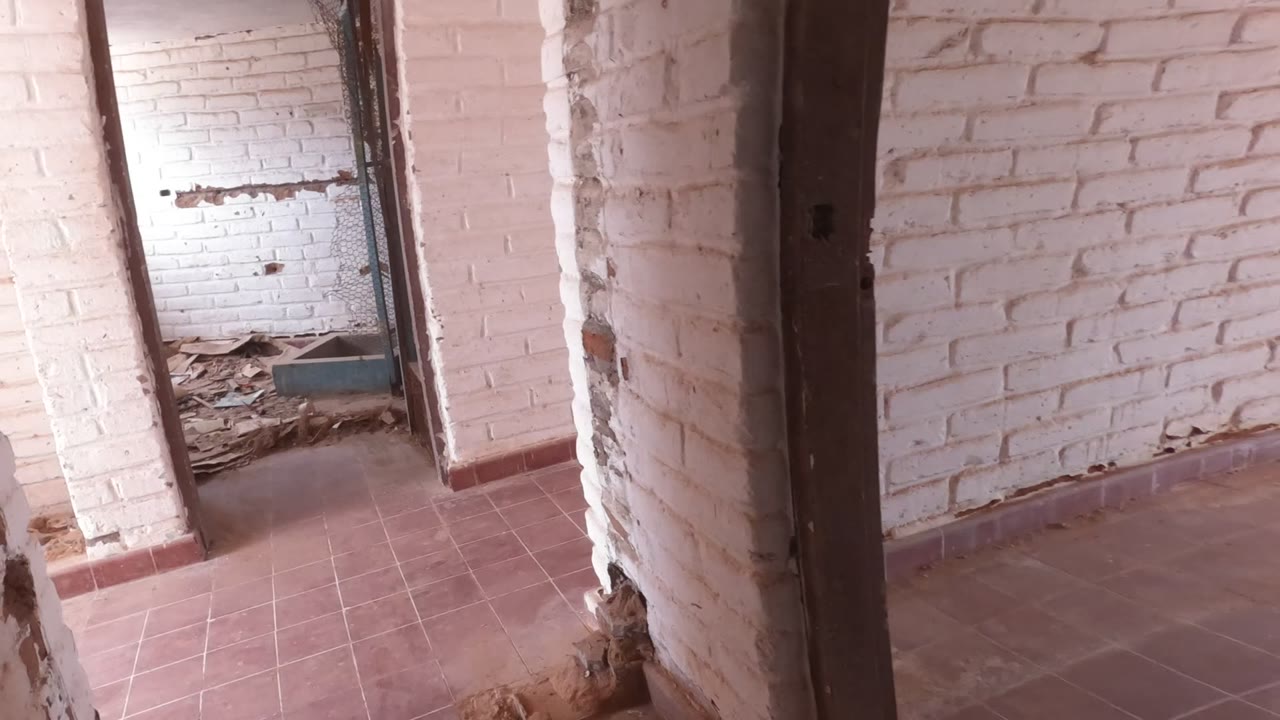 A brighter abandoned interior shows white brick walls, red-brown tiles, a rough doorway, and debris on the floor in Baja California, Mexico, with no visible people.
