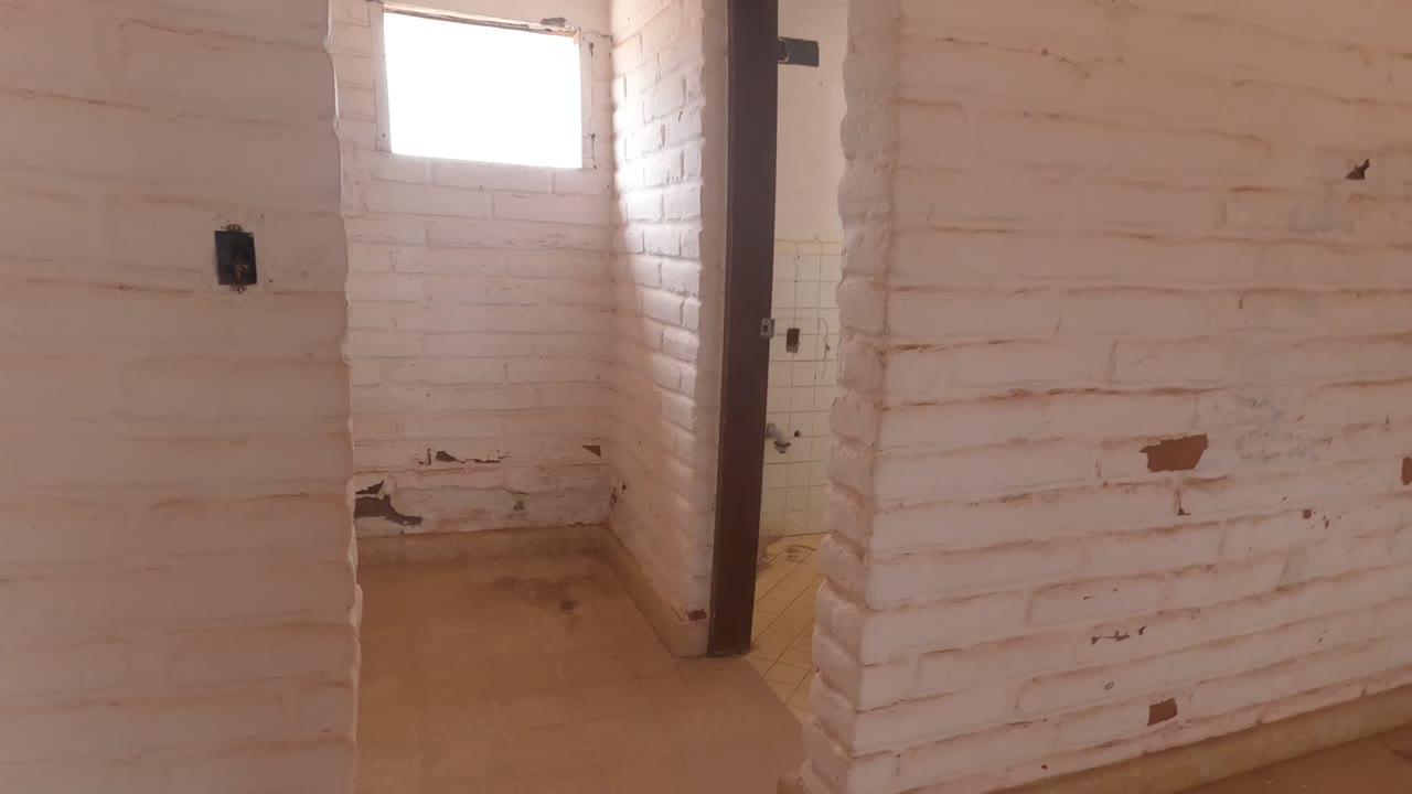 Worn white brick wall beside a dark door frame.