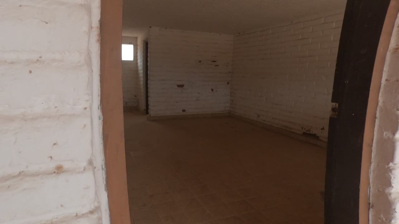 Interior room with white brick walls and a small bright window.