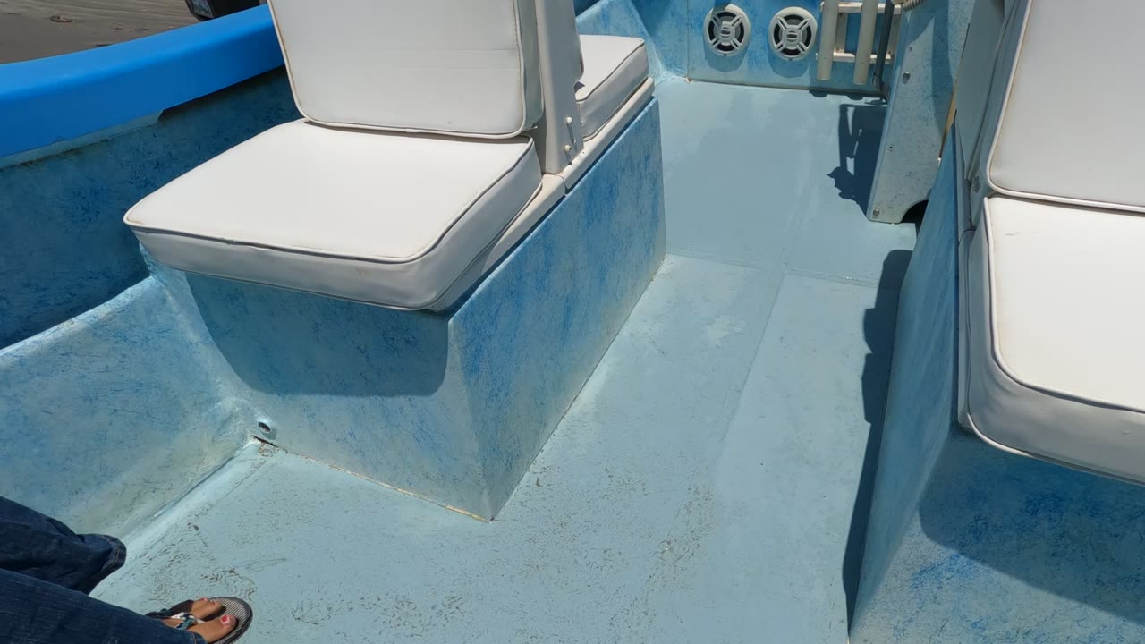 White cushioned seats and a pale blue boat deck fill the frame in Baja California, Mexico, with no visible people in this opening interior view.