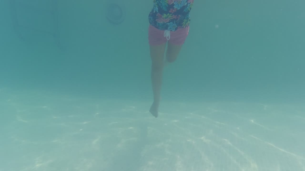 Child moving underwater toward the camera.
