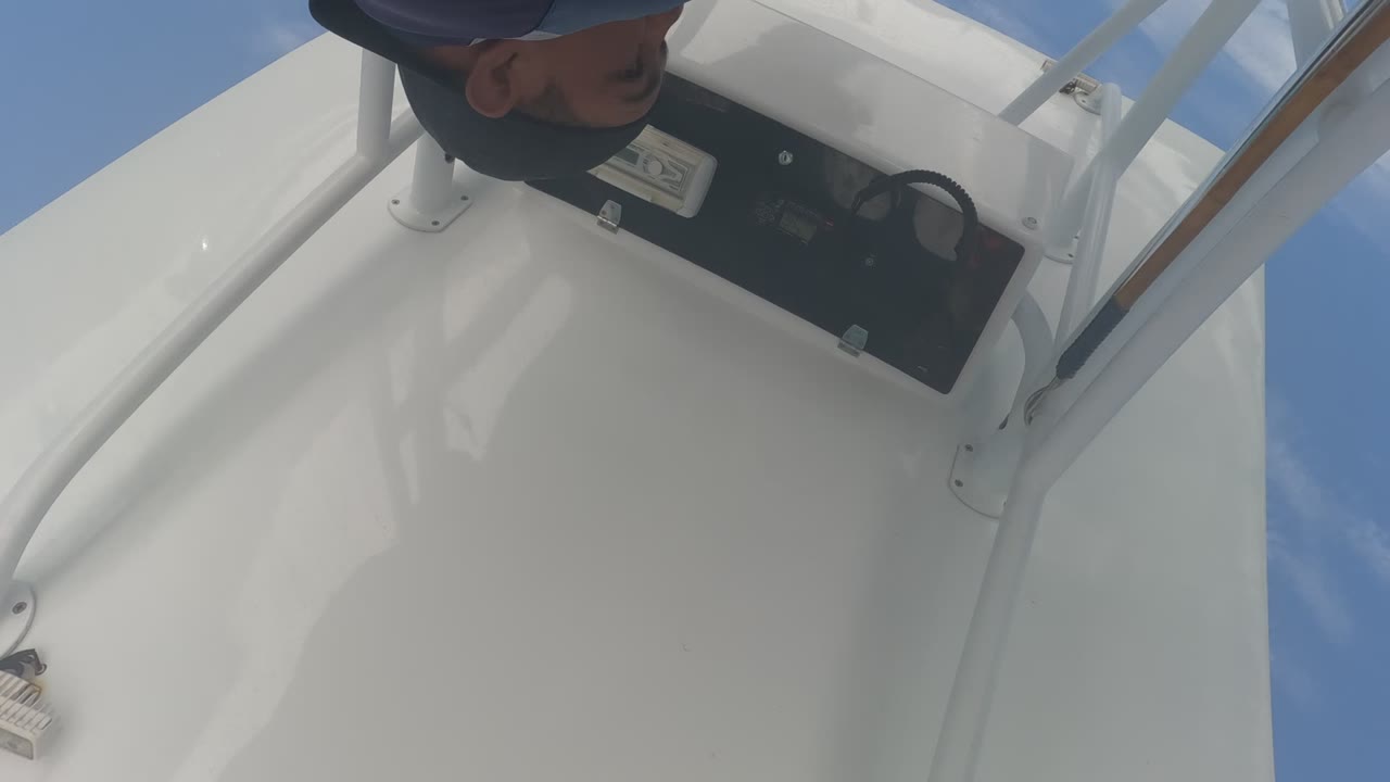 At 0:00 in Baja California, Mexico, a person in a dark blue long-sleeve shirt appears upside down near a black boat control panel on a white deck under blue sky.