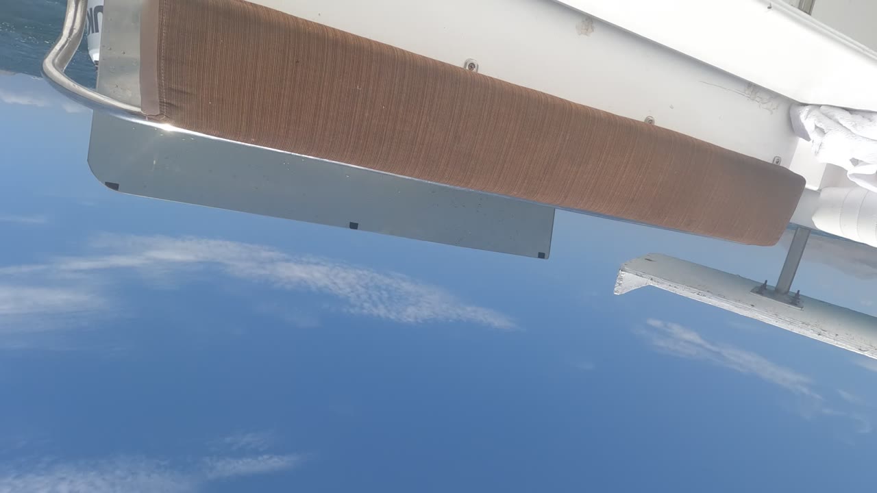 Brown yacht deck panel with ocean and clouds behind it