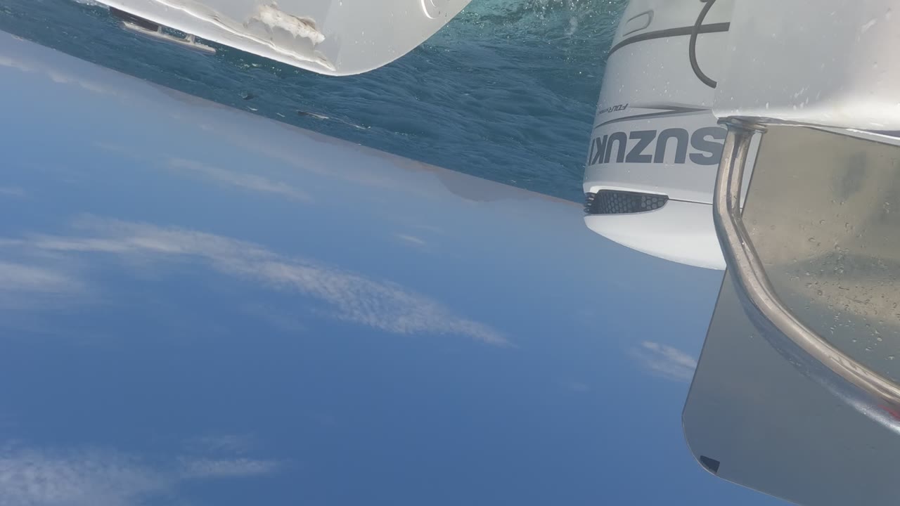 At 0:00, a tilted Baja California, Mexico boat view shows a partial Suzuki outboard and white hull above blue ocean and pale clouds, with no visible people.