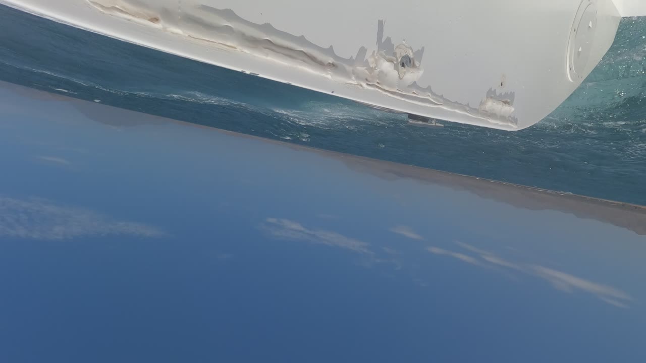 Ship hull over blue water and distant shoreline