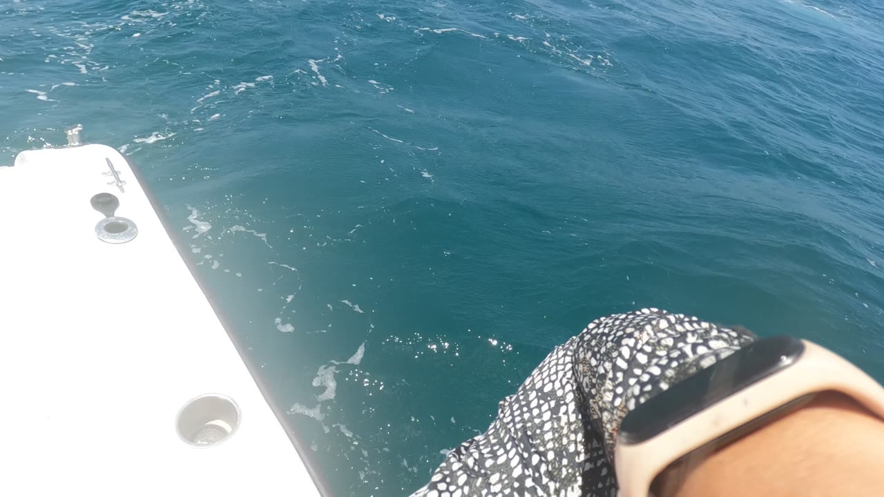 At 0:00 in Baja California, Mexico, blue ocean fills the frame beside a white boat edge, with a partial passenger arm, watch, and patterned sleeve at the bottom.
