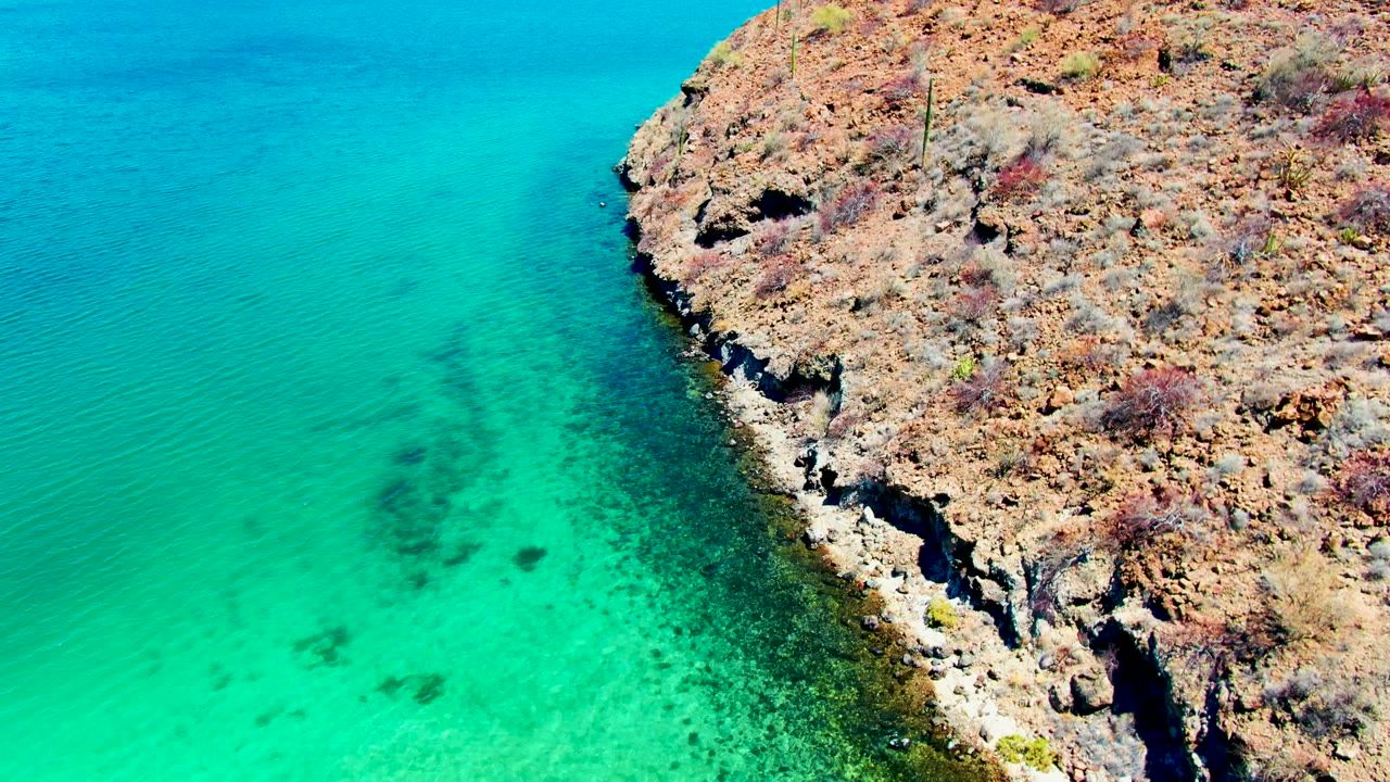 Clear blue-green sea along a rocky shore