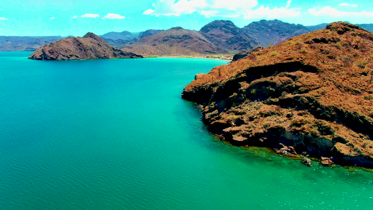 Rocky coastline fills the right side above turquoise water.