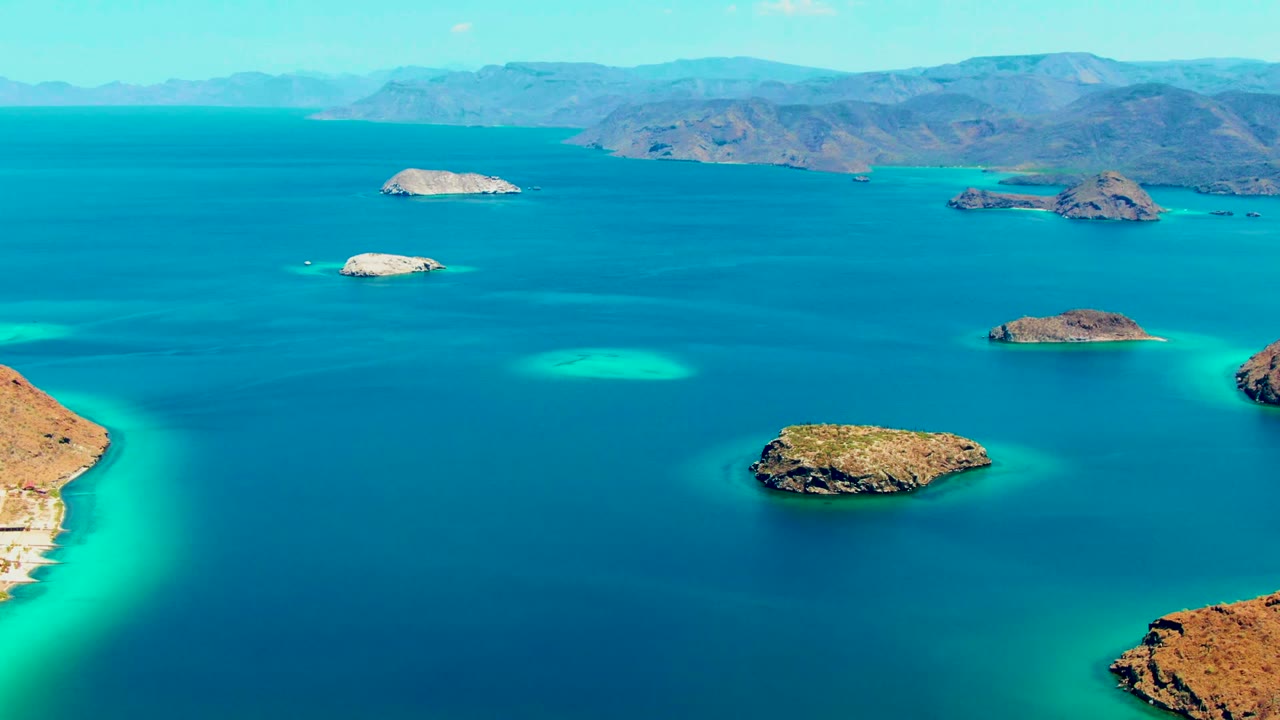 Small islands and shallow turquoise patches surrounded by blue ocean
