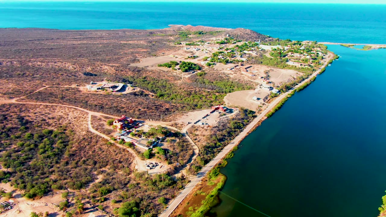 Drone view of shoreline road and scattered buildings
