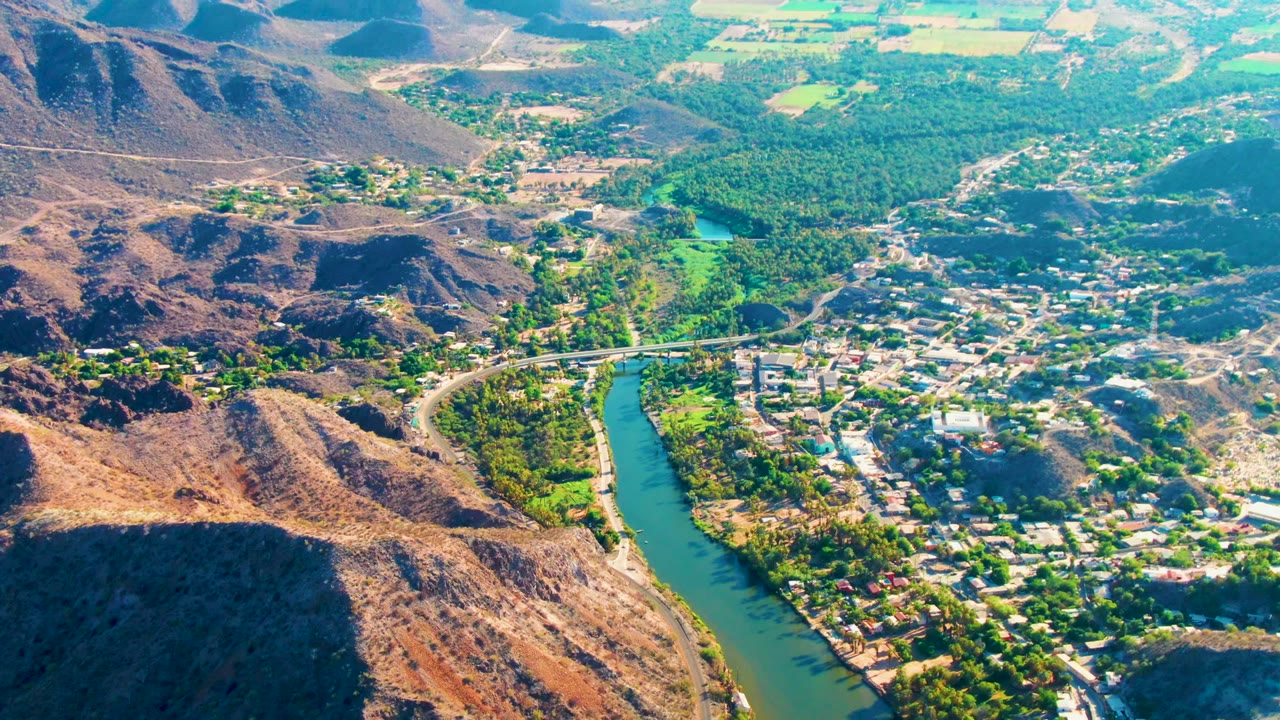 River, bridge, town blocks, and brown hills seen from above
