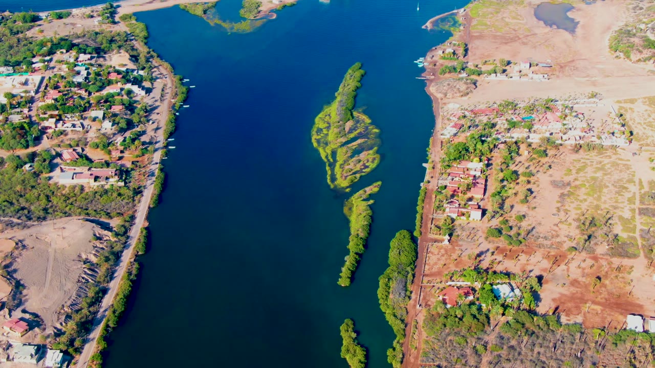 Overhead river scene with narrow green islands and homes along the bank.
