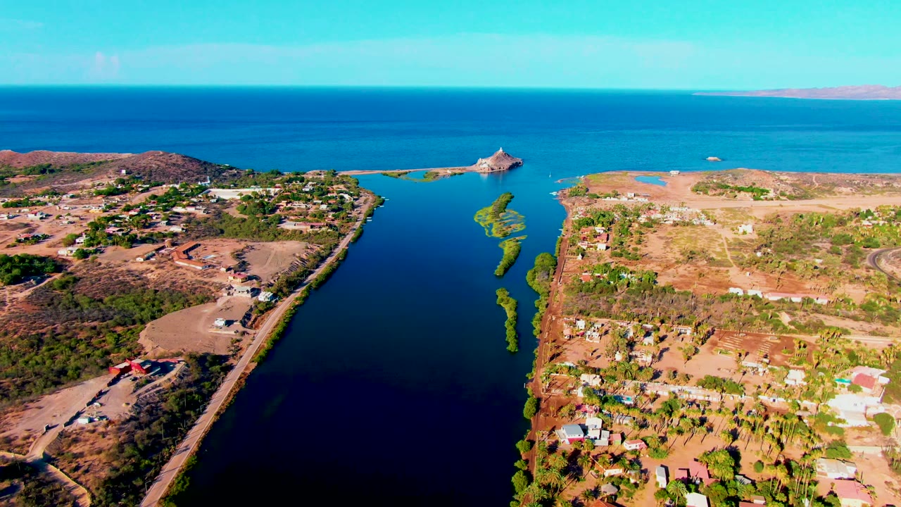Third frame presents the Mulege waterway from above, with sparse development on both sides, brown ground, green shoreline plants, a high blue horizon, and no visible people.