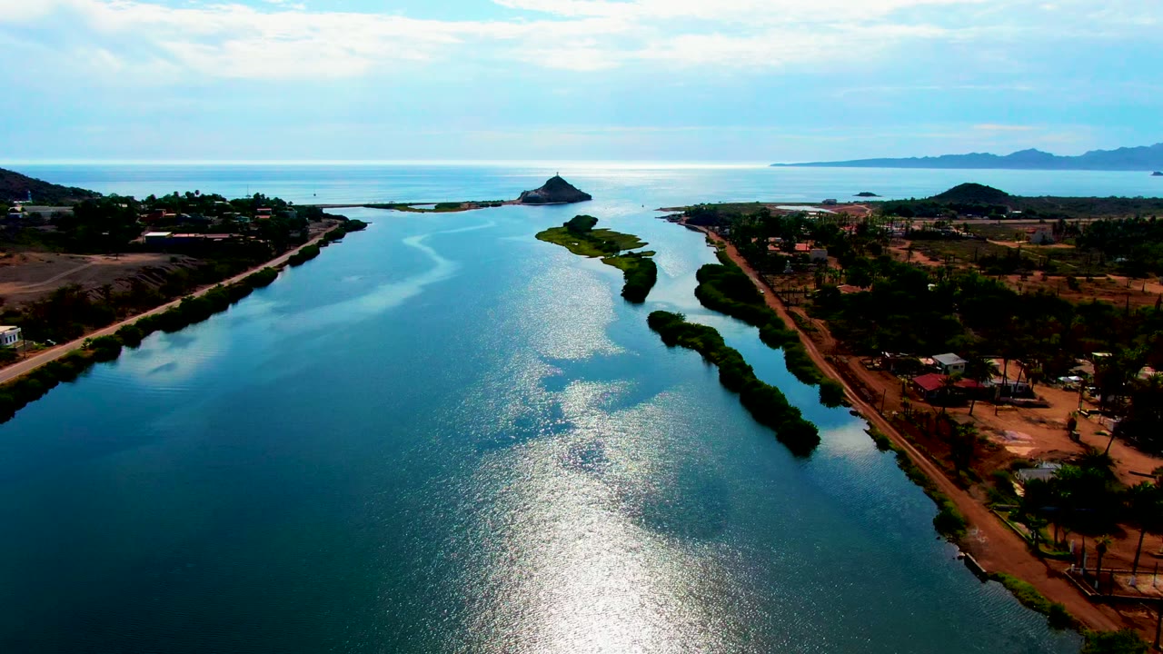 Drone view over reflective water with land on both banks