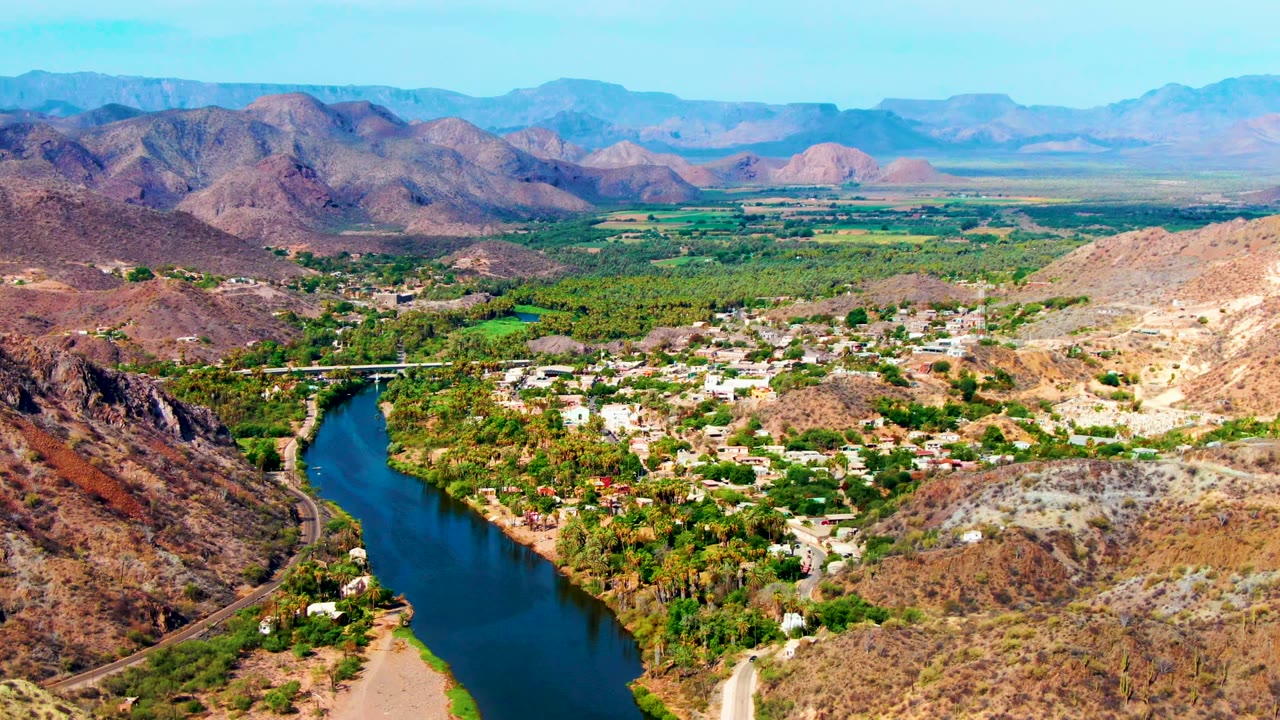 River bend beside a small town and desert hills