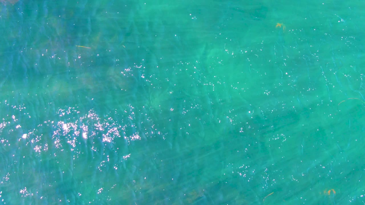 Clear turquoise water with a cluster of bright reflections.