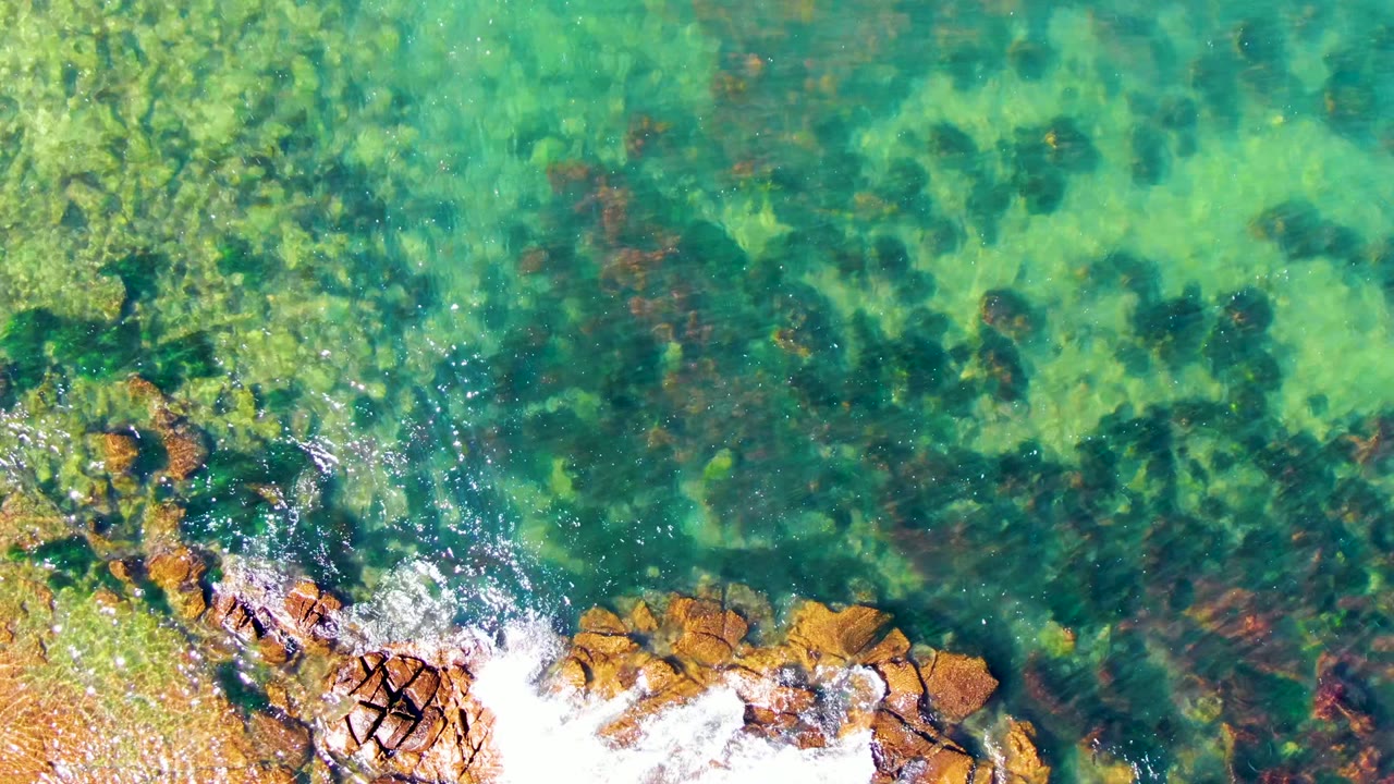 Clear shallow water over rocks with surf foam