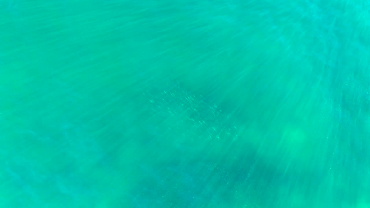 Clear green-blue water with soft ripple streaks.