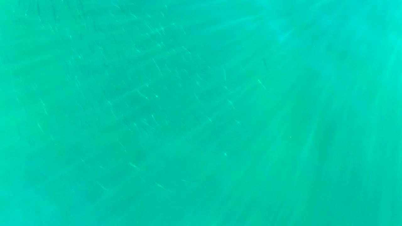 Turquoise water in La Bocana, Baja California Sur, with faint sun rays and no visible people at the opening moment.