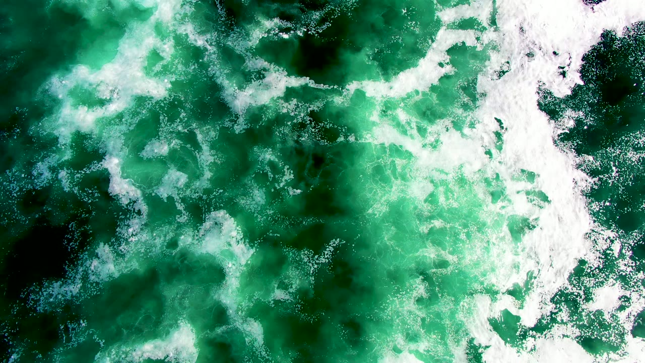 Overhead view of green ocean water and white foam at La Bocana, Baja California Sur, with no visible people in this opening frame.